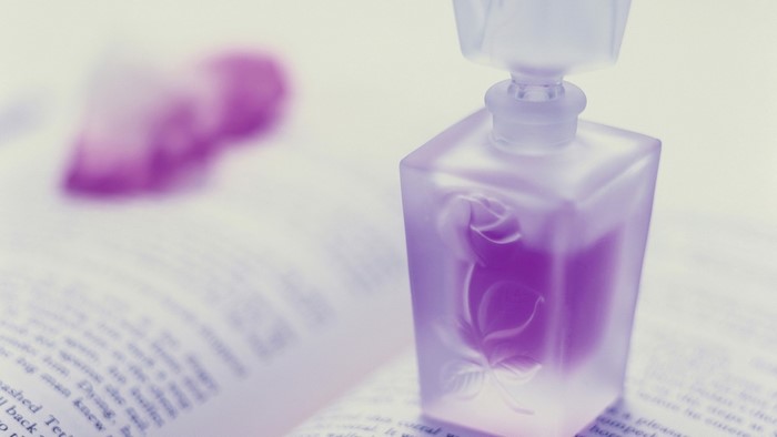 Perfume bottle with rose design on an open book