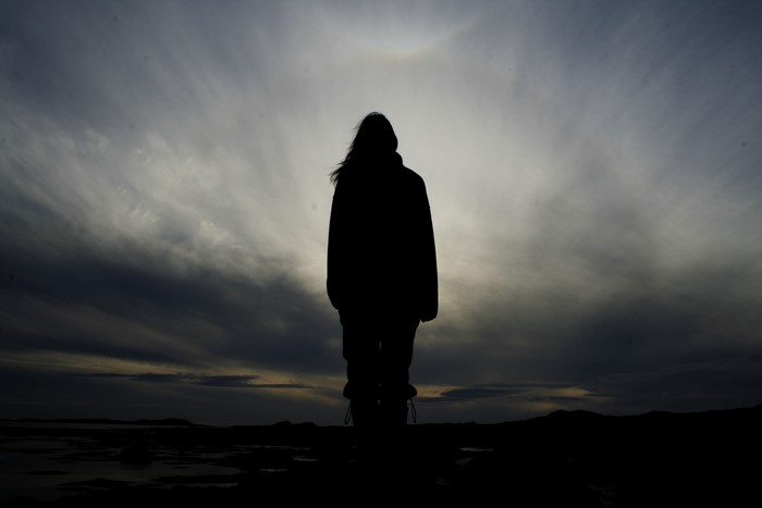 Silhouette of a person against a cloudy sky