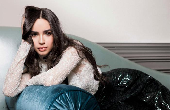 Sofia Carson on a blue chaise lounge