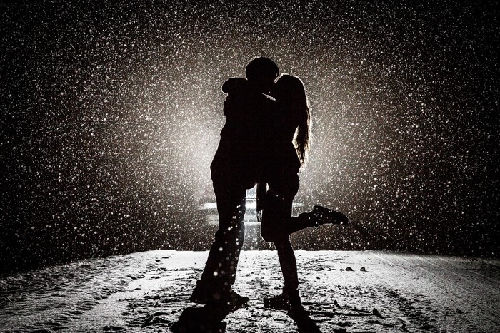 Silhouetted Couple Kissing in Snowfall