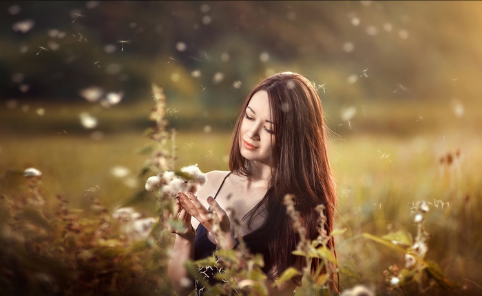 Brunette Girl with Dandelions in Sunlit Field