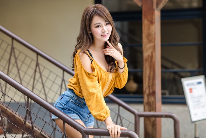 Smiling Young Woman in Yellow Top and Denim Shorts