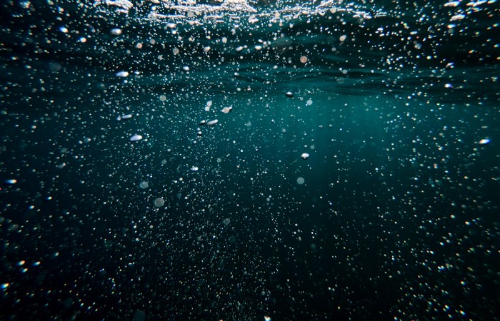 Underwater bubbles in dark blue ocean water