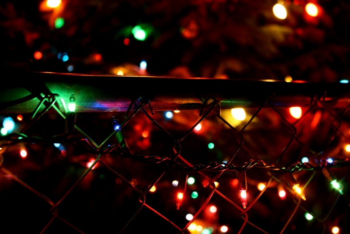 Christmas lights on a fence at night