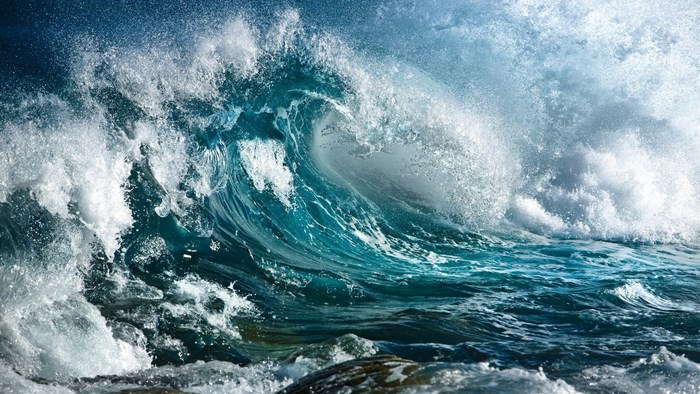 Crashing ocean wave with spray and rocks