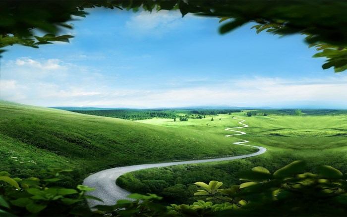 Winding road through green hills under blue sky