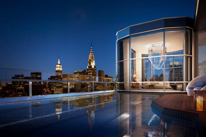New York City skyline at night from a balcony with pool