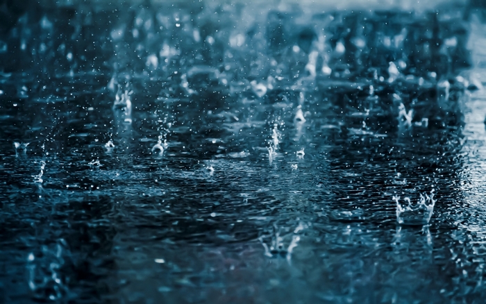 Raindrops falling on a dark surface