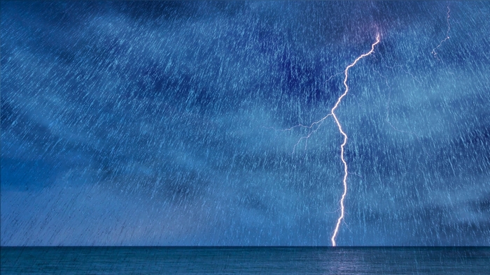 Lightning strike over the ocean during a rainstorm