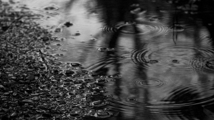 Raindrops on water with pebbles