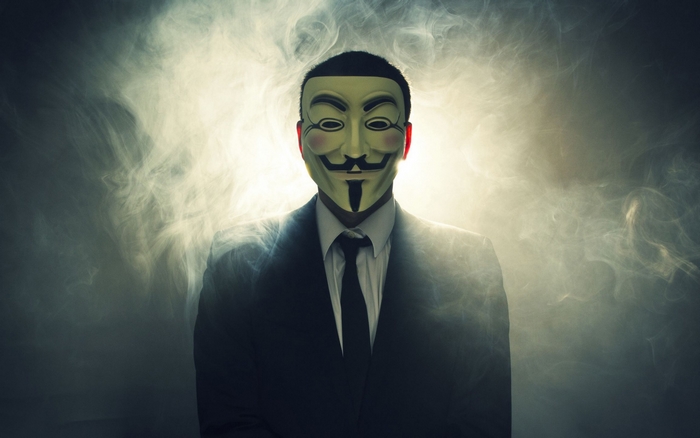Man in Anonymous mask and suit with smoke