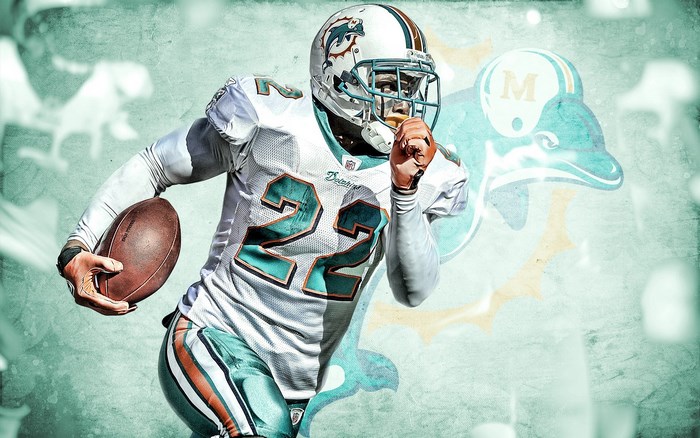Miami Dolphins player number 22 running with football