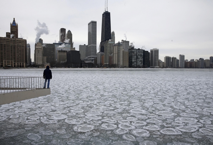 Chicago skyline over frozen lake with person on pier