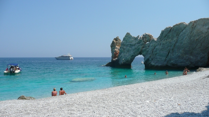 Beach with rock arch and boats