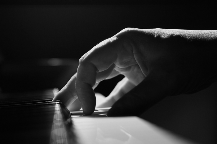 Close-up of a hand playing a piano