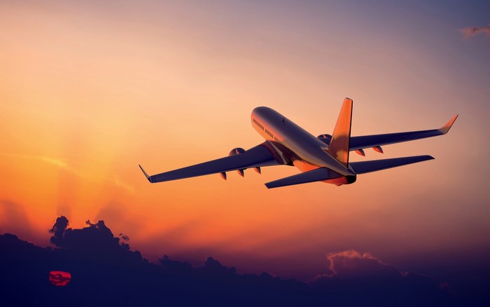 Airplane flying at sunset