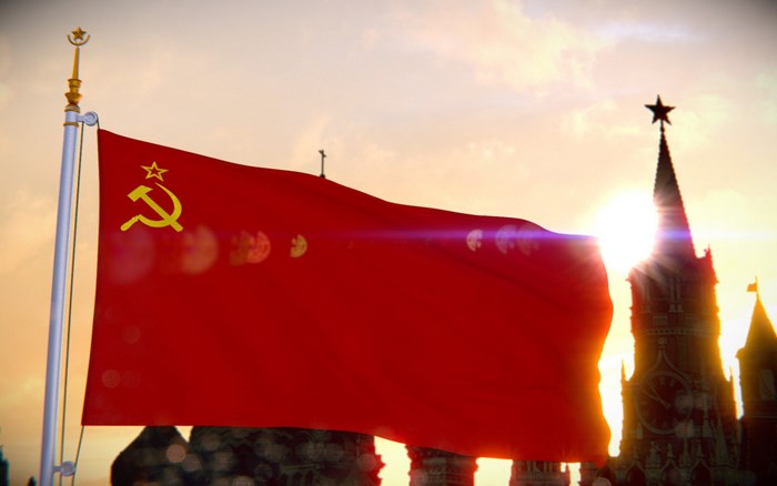 Soviet Union flag waving at sunset with Kremlin towers
