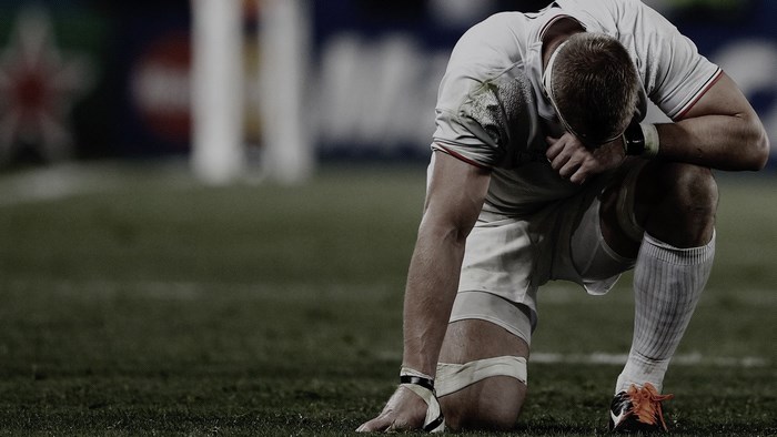 Rugby player kneeling on field