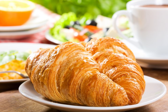 Croissants with breakfast in the background