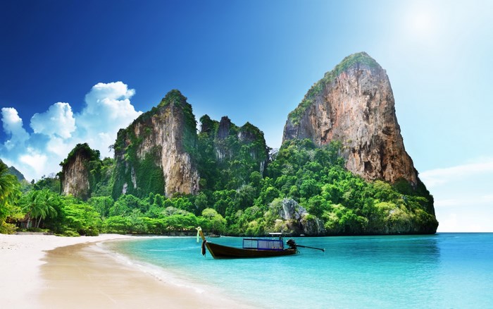 Tropical beach with limestone cliffs and boat