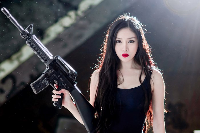 Woman Holding a Rifle with Intense Gaze