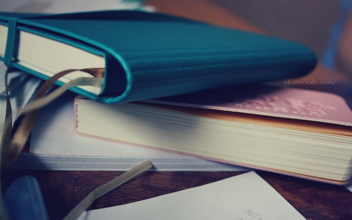 Two notebooks on a wooden table