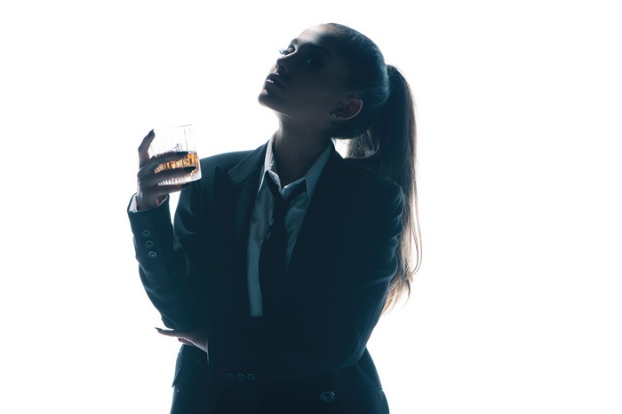 Ariana Grande in a suit holding a drink