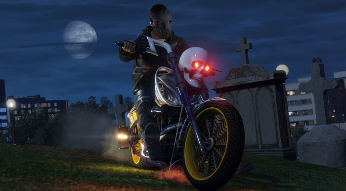 Man on skull motorcycle in cemetery at night