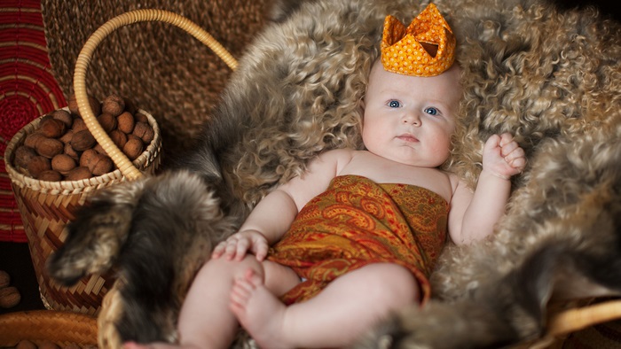 Baby wearing a crown and patterned cloth