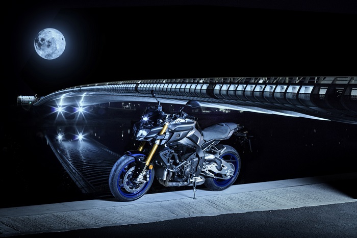 Yamaha motorcycle under a bridge at night with moon
