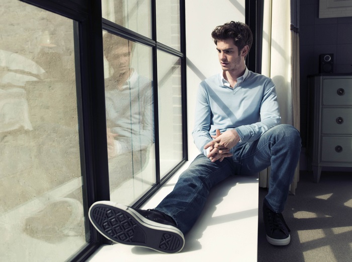 Andrew Garfield sitting by a window