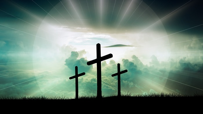 Three crosses on a hill with light rays