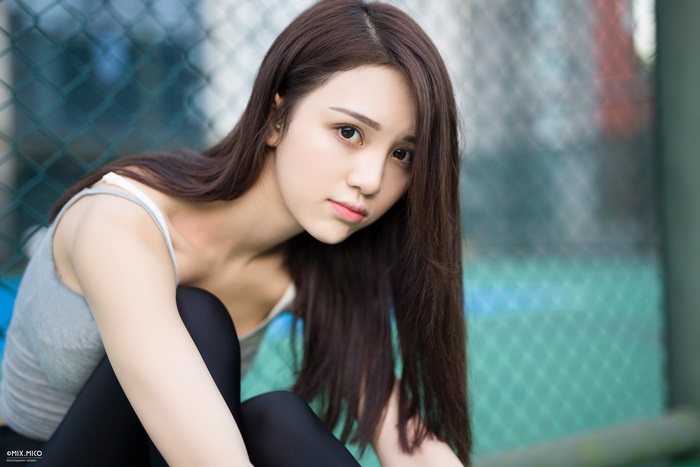 Asian woman in grey tank top and black leggings