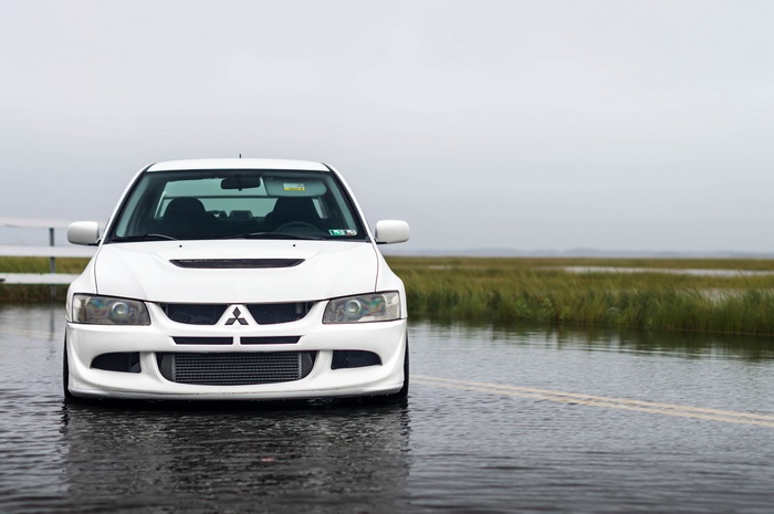 White Mitsubishi Lancer Evolution VIII in flooded road