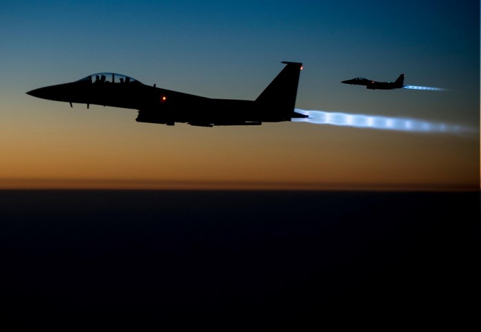 Two F-15 Eagle fighter jets flying at dusk