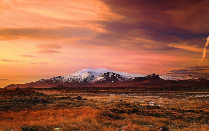 Snow-capped mountain range at sunset in Iceland