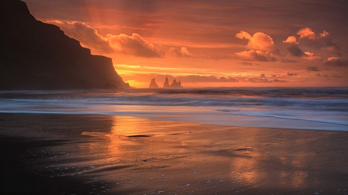 Sunset Glow Over Rocky Beach and Ocean Waves