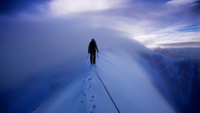 Climber on Mont Blanc ridge in clouds