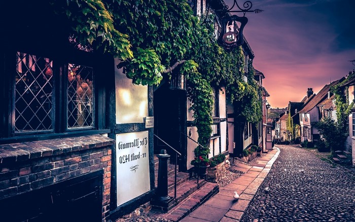 Old tavern on a cobblestone street at sunset