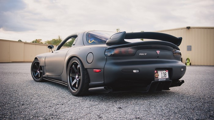 Matte black Mazda RX-7 with large rear spoiler