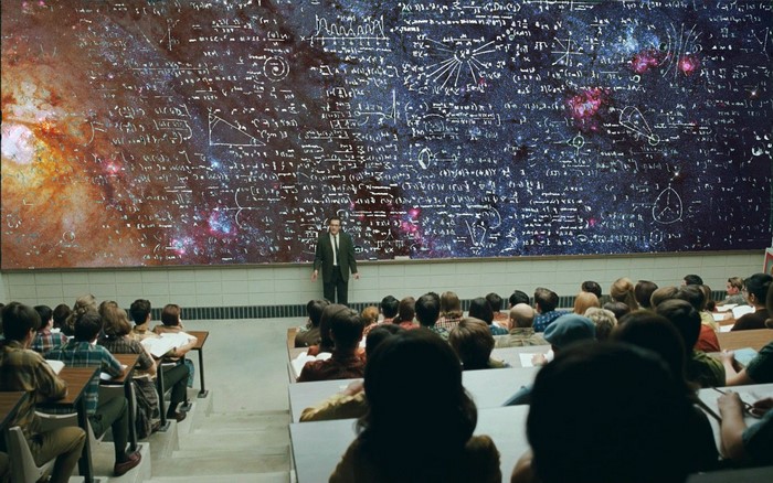 Professor lecturing students on a blackboard with space imagery