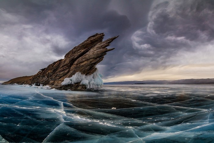 Frozen Lake Baikal with Jagged Rock Formation and Stormy Sky