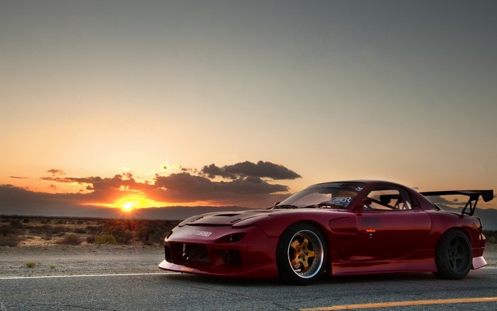 Red Mazda RX-7 sports car at sunset