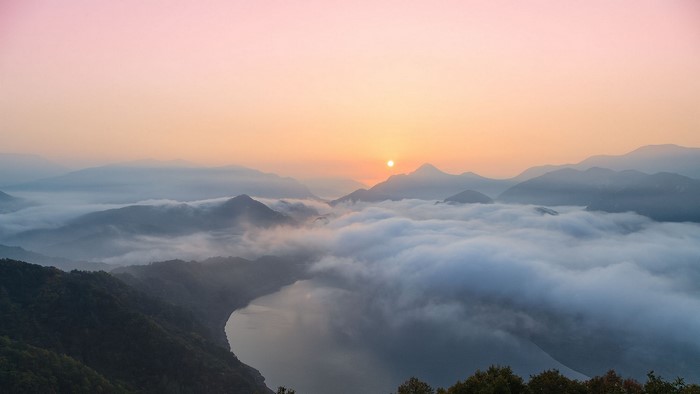 Sunrise over misty mountains and lake in South Korea