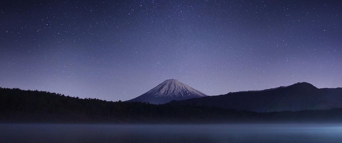 Starry Night Sky Over Mountain Silhouette