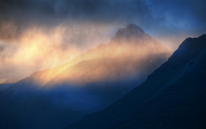 Mountain peaks shrouded in mist with golden sunlight