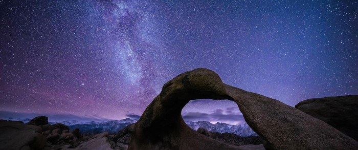 Milky Way over rock arch and mountains