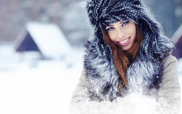 Woman in fur hat and coat in snow