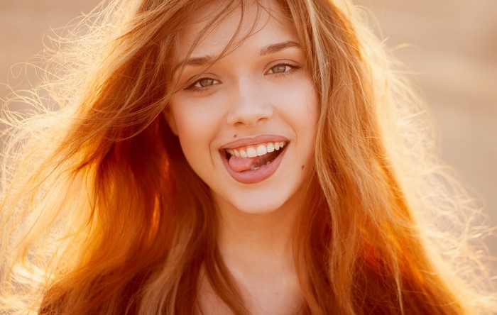 Woman with red hair sticking out her tongue