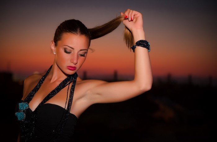 Woman holding her ponytail at sunset